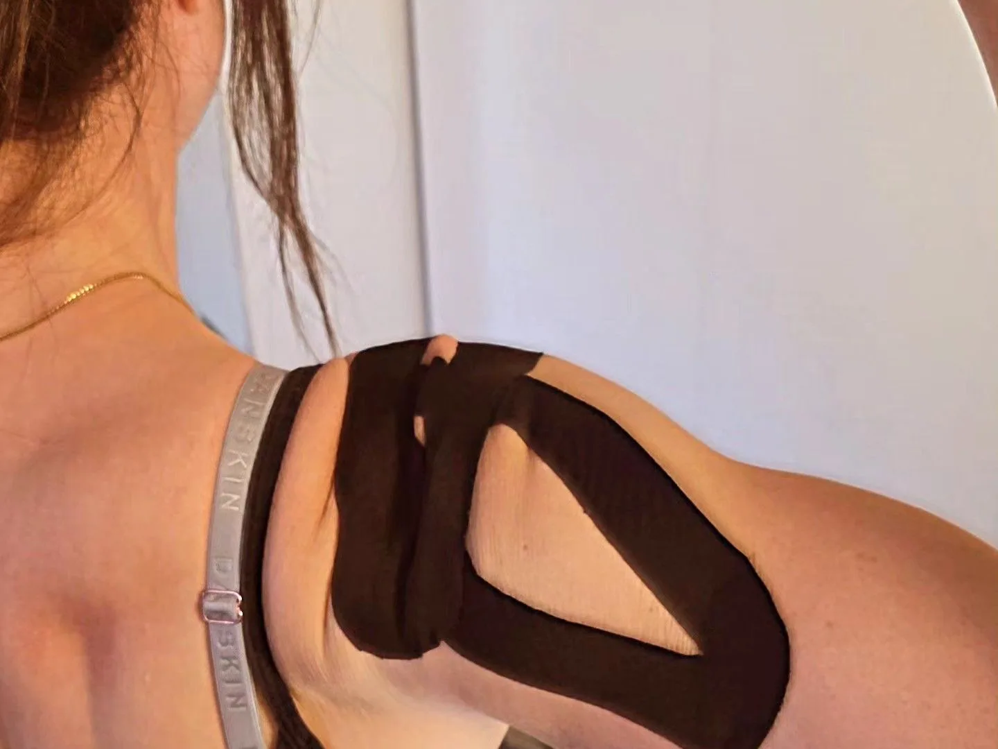 A practitioner assesses a client’s shoulder movement during a consultation